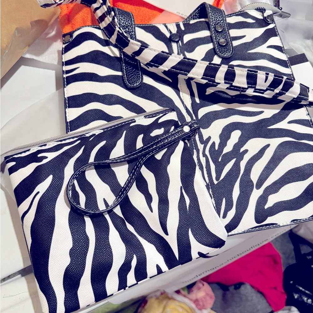 Brand new Modern and Chic purse. Never carried. matching clutch and strap.